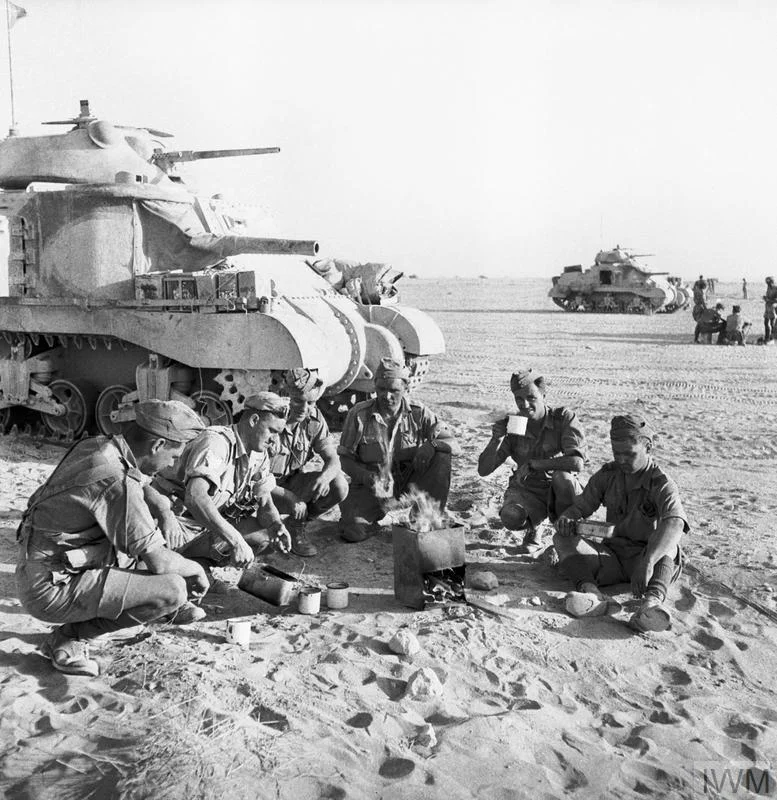 Grant tank crews sit down to a brew near their vehicles, Libya, 8 Jun 1942. IWM photo E 13106