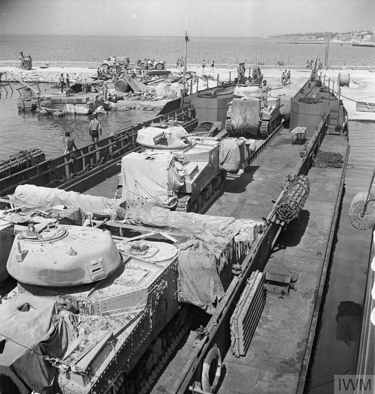 Grant tanks, including flail variants, embarking onto a landing craft at Tripoli, 3 Jul 1943. IWM photo NA 3989