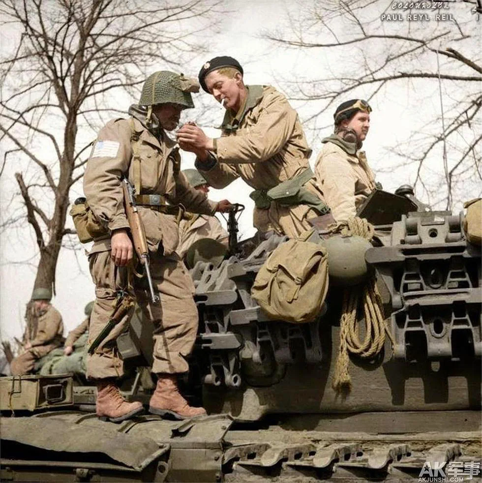 17th Airborne Division paratrooper gets a light from a Churchill tank crewman of 6th Guards Armoured Brigade near Dorsten in North Rhine-Westphalia, Germany, 29 Mar 1945.