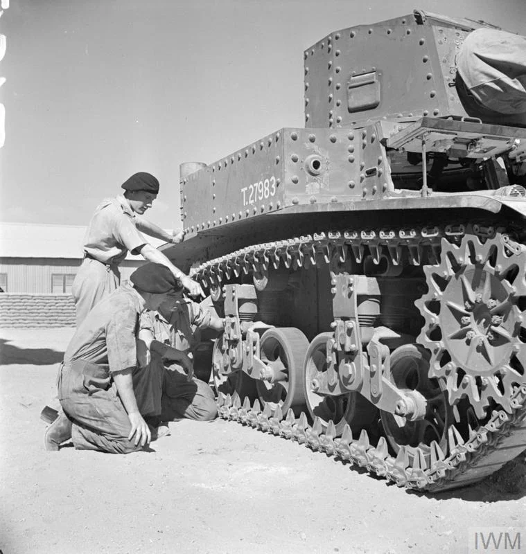Men of the Royal Tank Regiment examining the tracks and suspension of the new American M3 Stuart tank at a training depot in Egypt, 17 Aug 1941. IWM photo E 3443E.