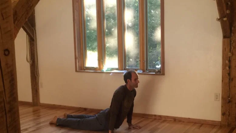 Christopher Grant, owner of Yoga Farm, demonstrates a pose for a yoga class.