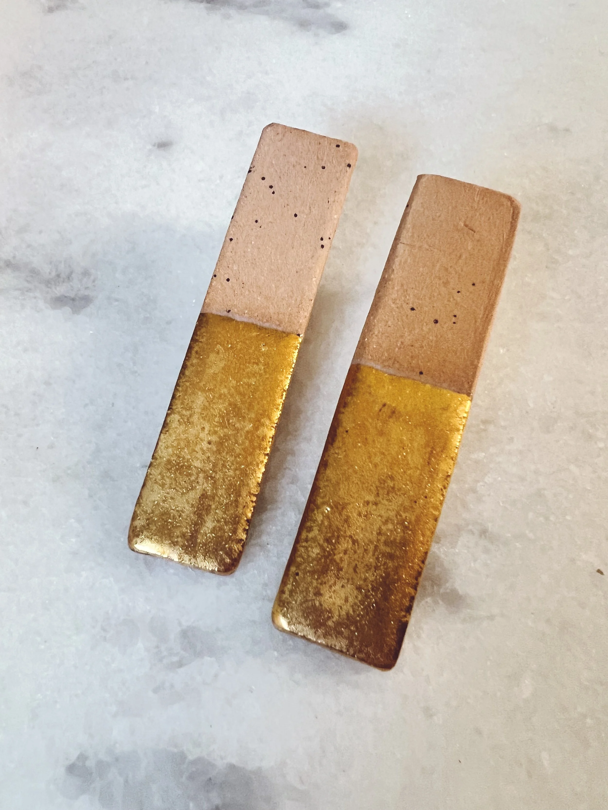 Gold dipped rectangles in sand