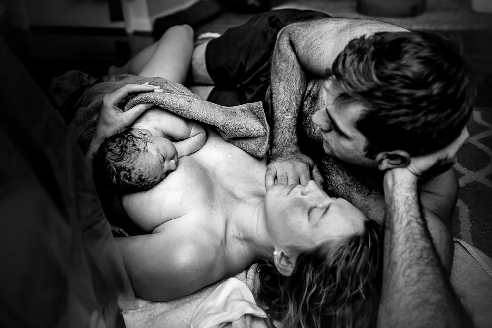 a black and white photo of mother father and their fresh newborn.jpg