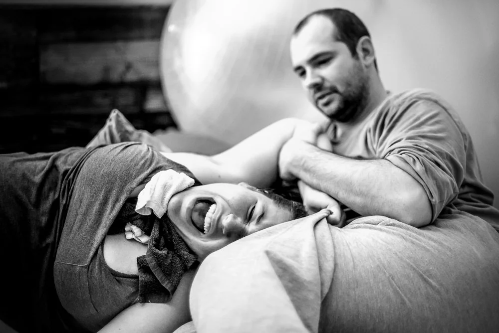 laboring mama needs the support of her husband as she moans through a hard contraction during her home birth in St. Louis.jpg