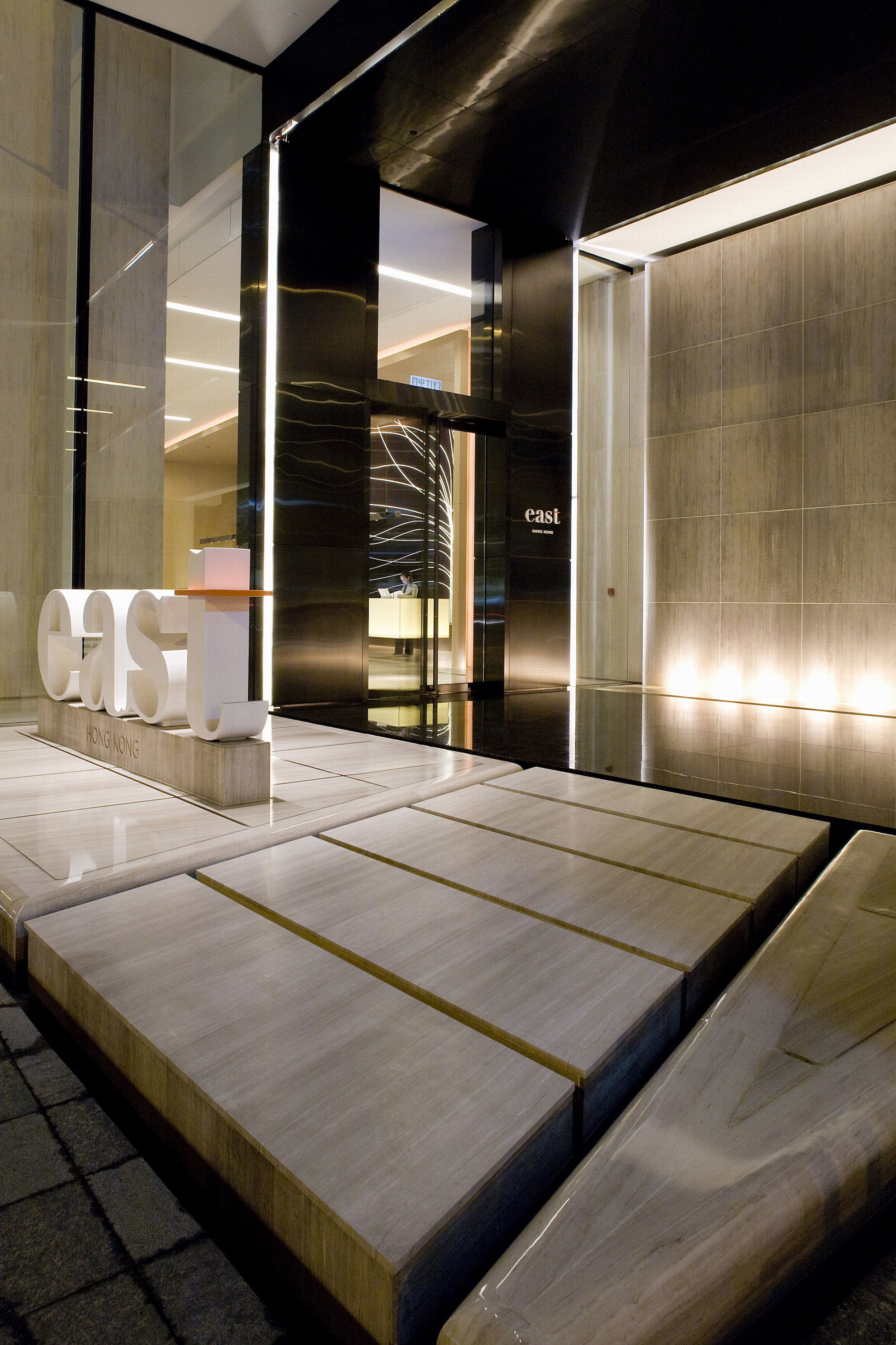 Yin and Yang: A serene, 35ft. long, back illuminated reception desk cantilevered from a single column, vs a glass grand stair with a labyrinth of steel and wood to symbolize the energy of Hong Kong.