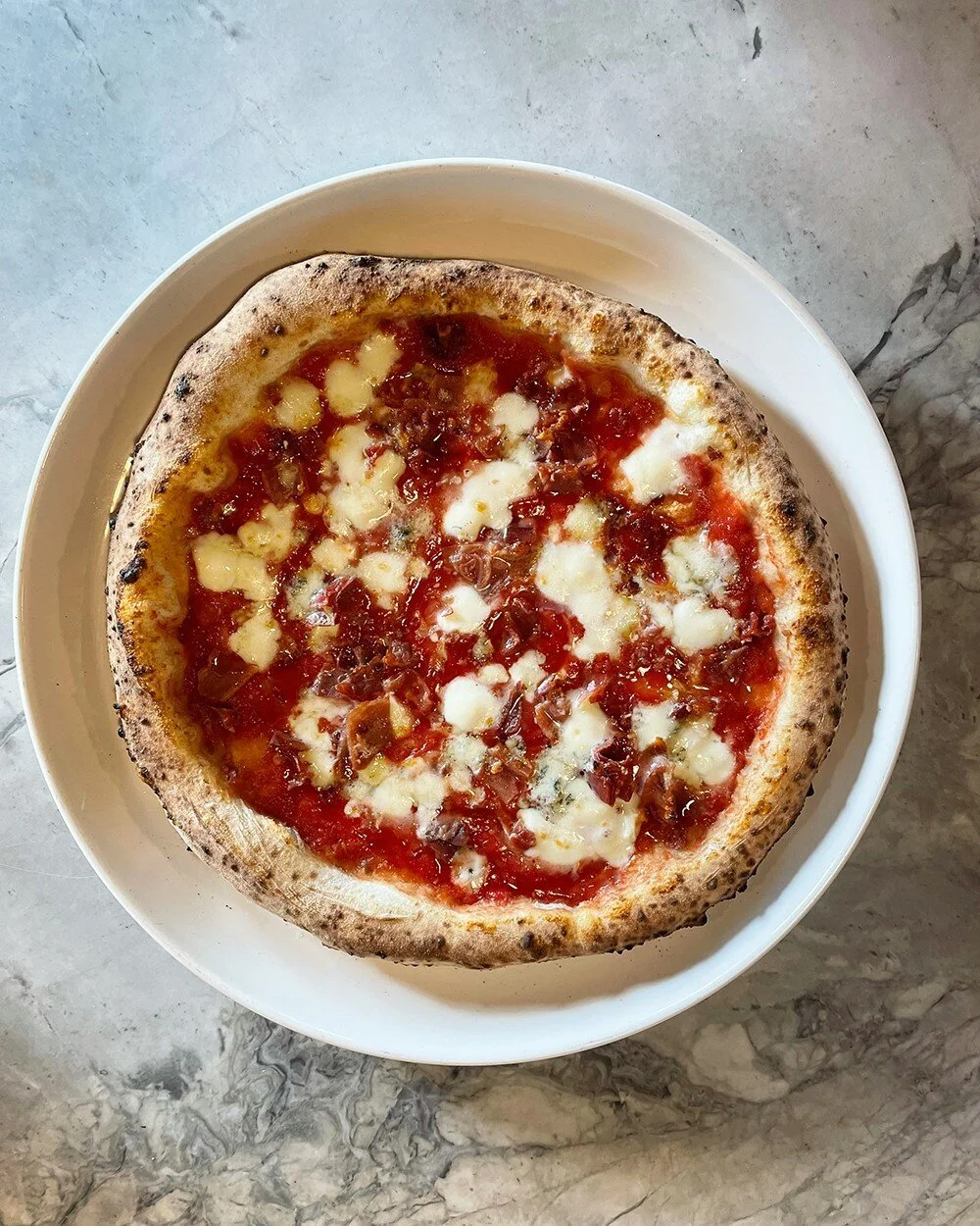 Introducing &mdash; The Heather!
This #PizzaOfTheWeek features a tomato base topped with a pinch of chili flakes, Fior di Latte mozzarella, gorgonzola cheese, crispy prosciutto and a honey garnish. Try it while you can... it's only here until October
