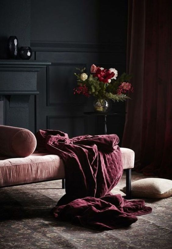 A dark interior , with a comfortable chaise for reading.