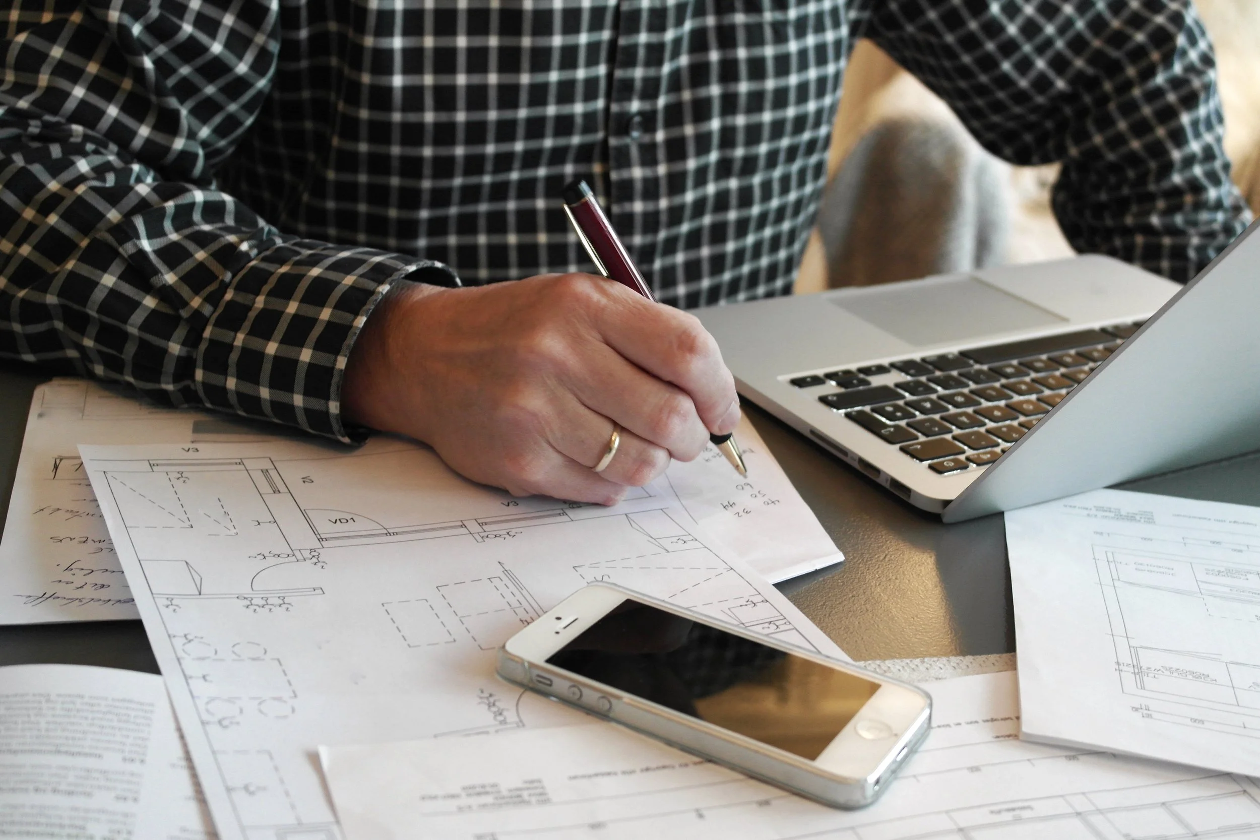Architect with blueprint, phone and laptop