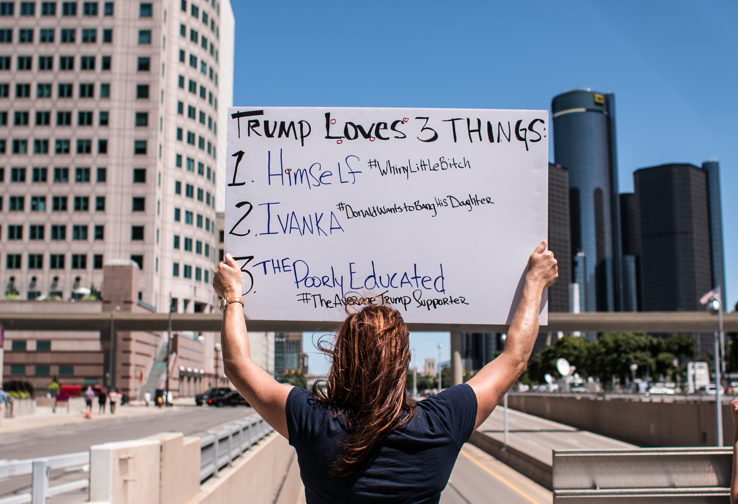  An anti Trump protester holds a sign overlooking the freeway as people gather in front of the Cobo Center to protest Republican Presidential candidate Donald Trump on August 8, 2016 in Detroit, Michigan. 