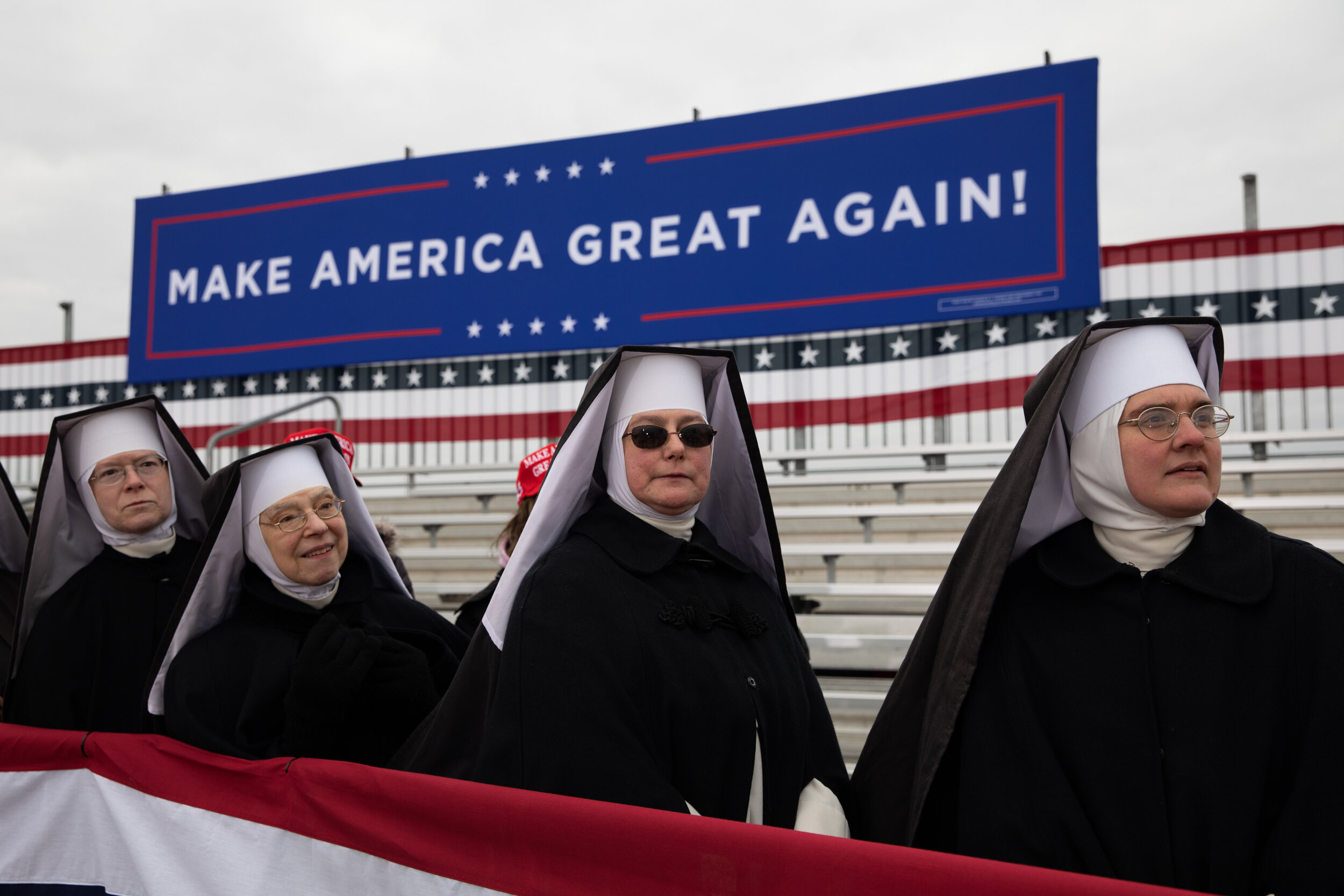  Nuns stand in front of a 'Make America Great Again' sign while waiting for the arrival of U.S. President Donald Trump during a rally in Waterford, Michigan, U.S., on Friday, Oct. 30, 2020. (For Bloomberg) 