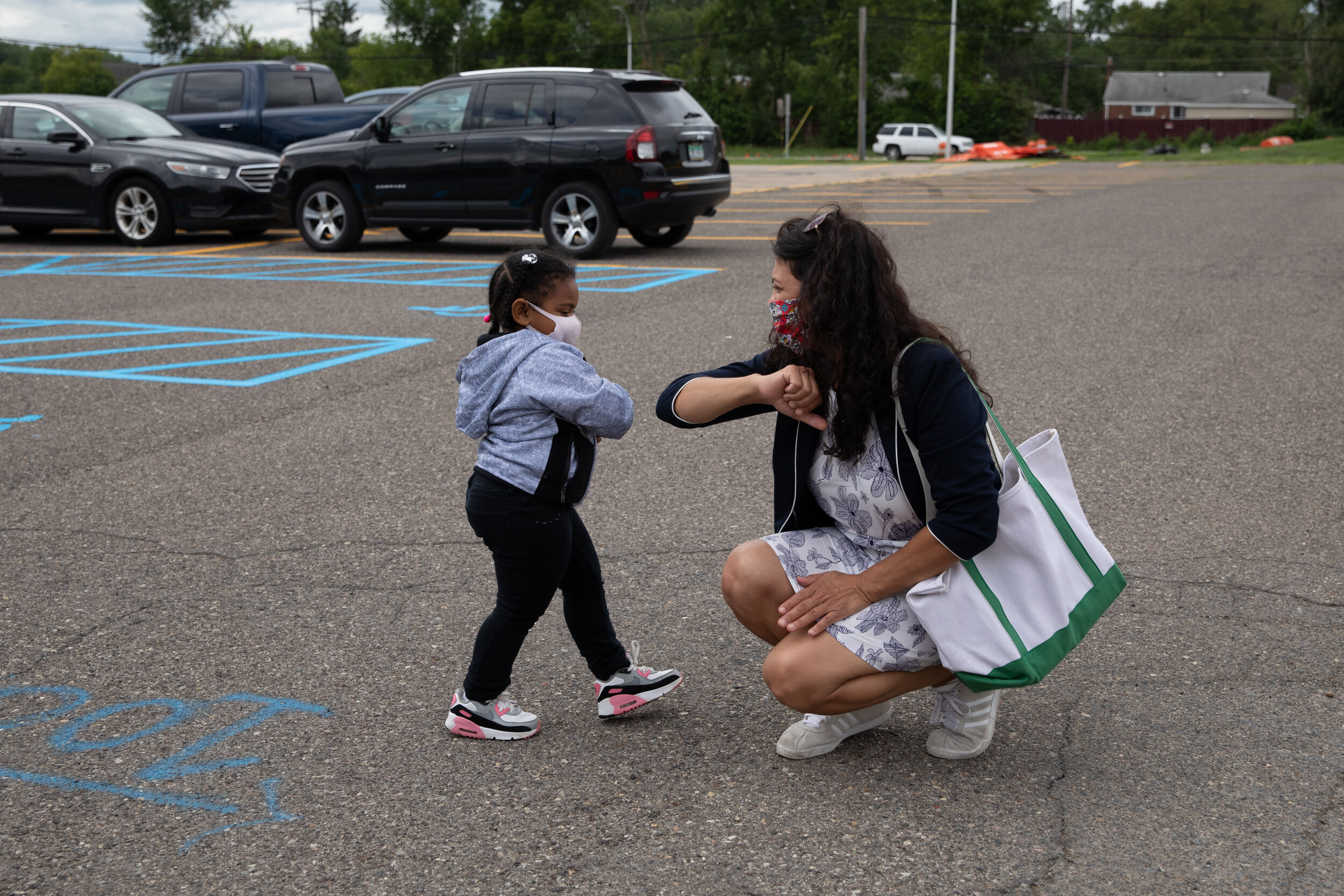  Rep. Rashida Tlaib, D-Detroit elbow bumps a young girl as she visits different voting sites on the day of the primary election on August, 4, 2020 in Inkster, Michigan.  Tlaib defeated primary challenger Detroit City Council President Brenda Jones in