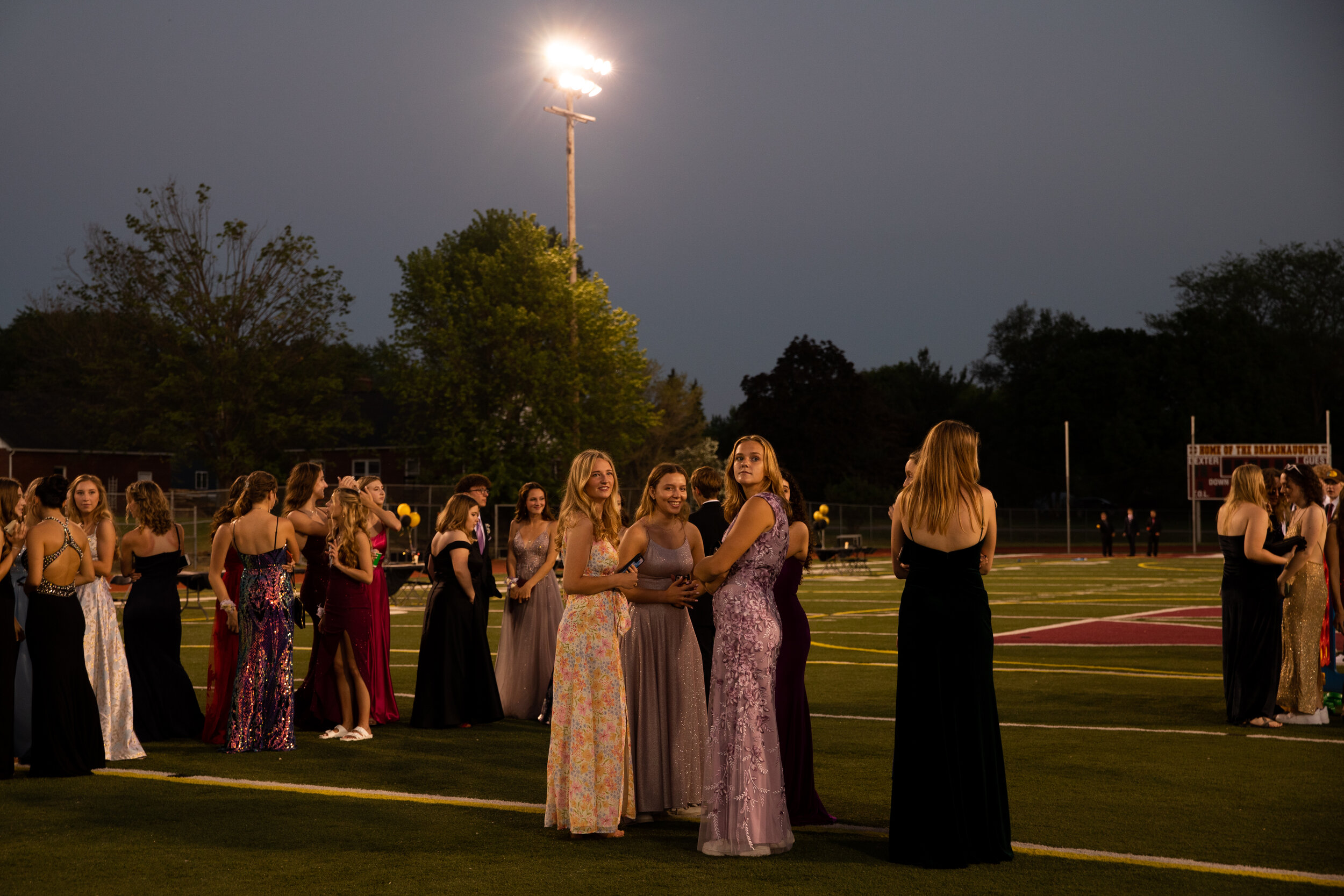  A group of friends gather on the football field during their prom celebration in Dexter, Michigan, U.S. on Saturday, May 22, 2021. (Emily Elconin for The New York Times) 