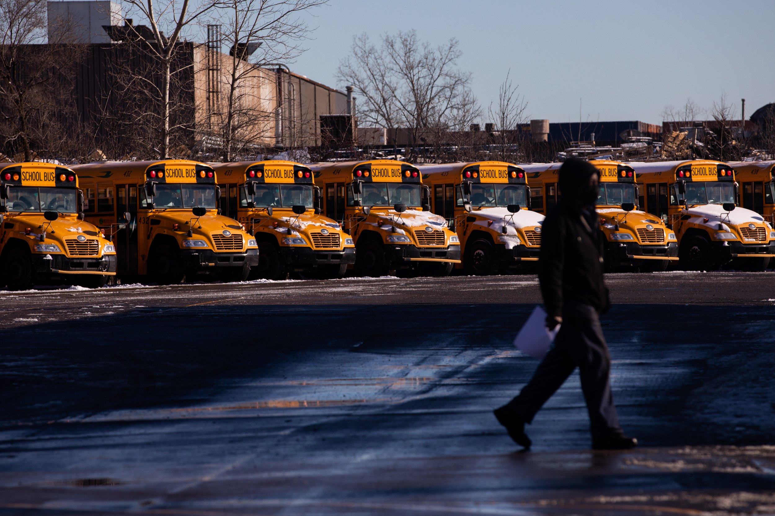  Rows of school buses sit idle in a parking lt at ABC Transportation in Detroit, Michigan, U.S., January 3, 2022.  (Emily Elconin for The New York Times) 