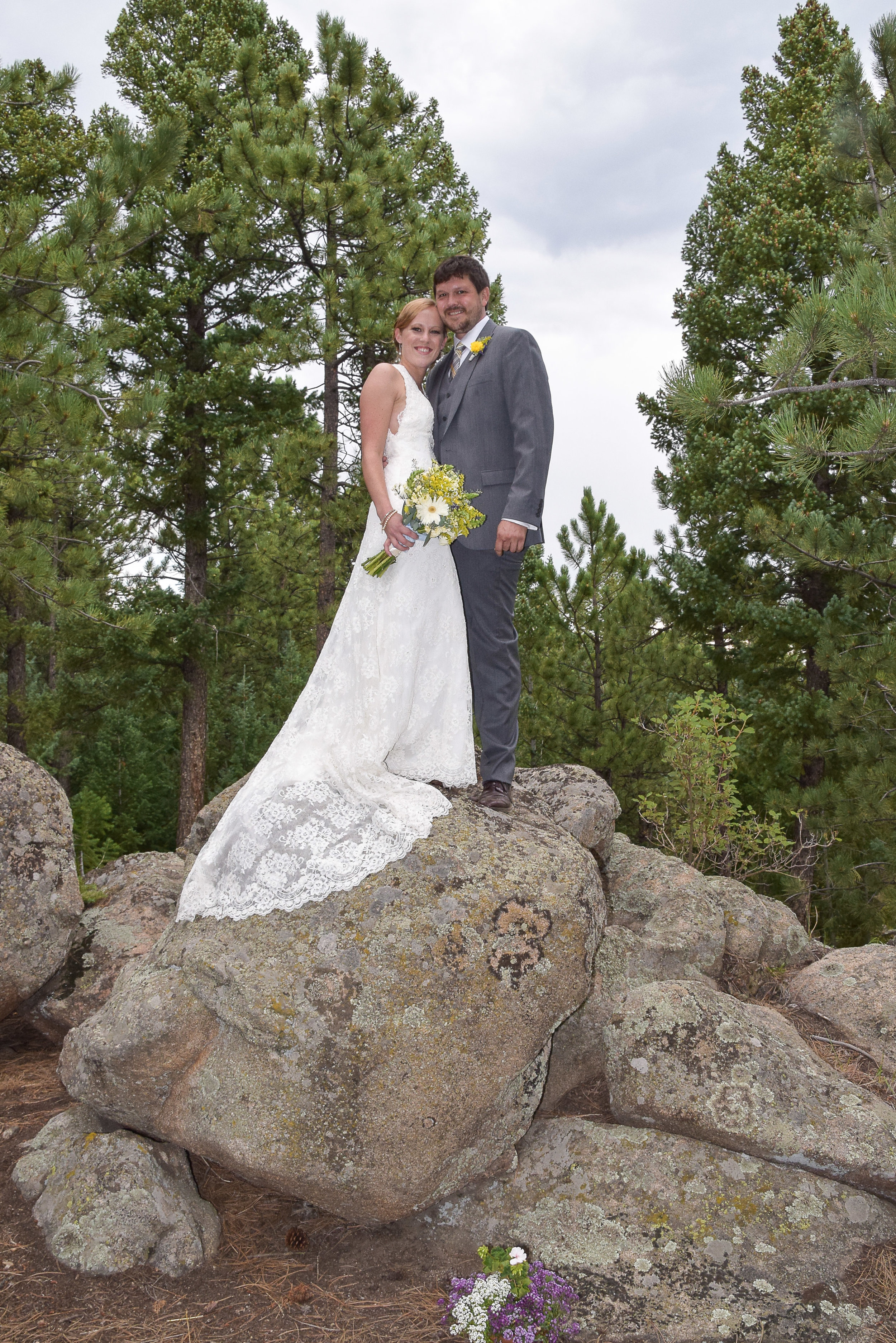 Bride and Groom standing on top of rock.