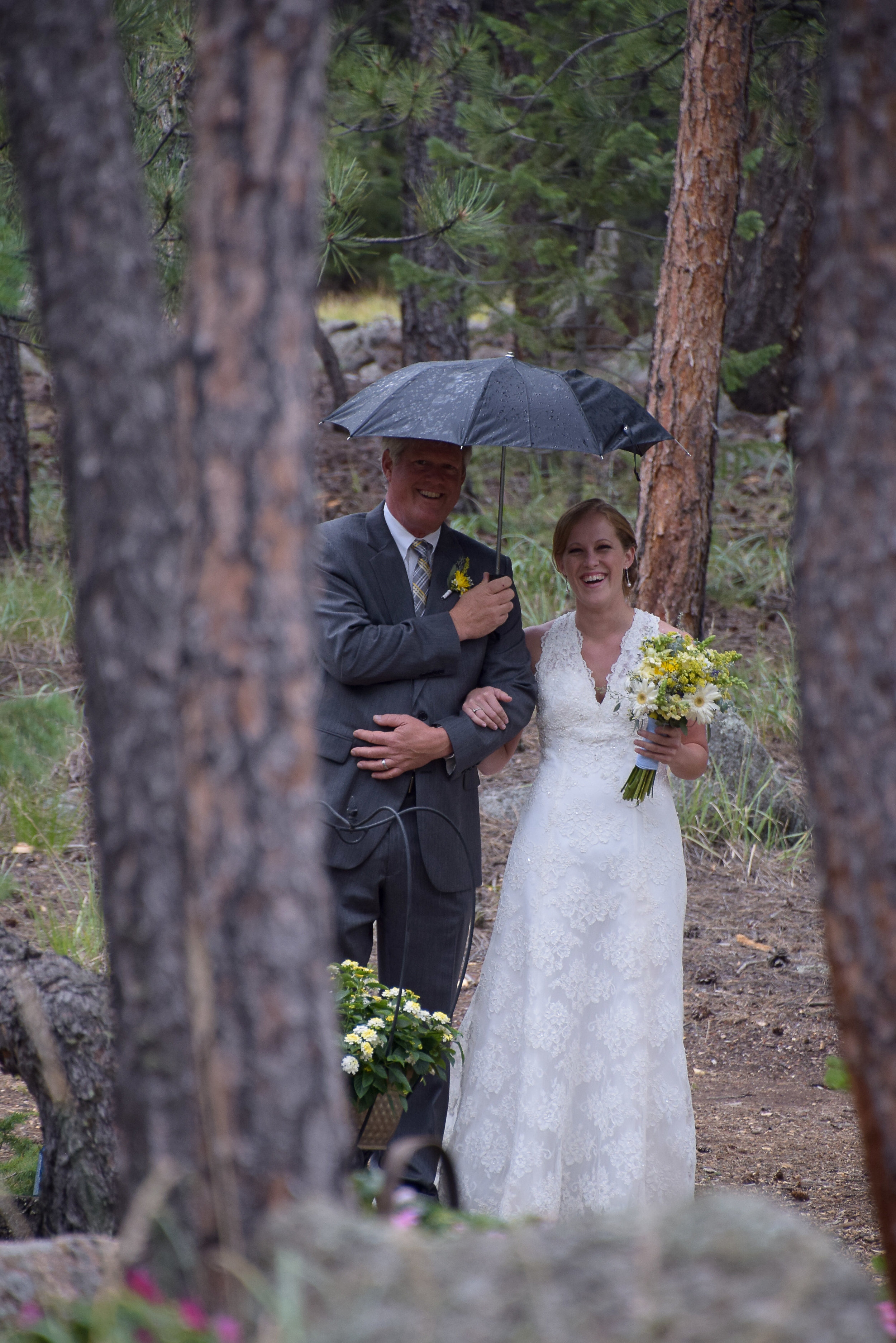 Dad walking bride to altar with umbrella.