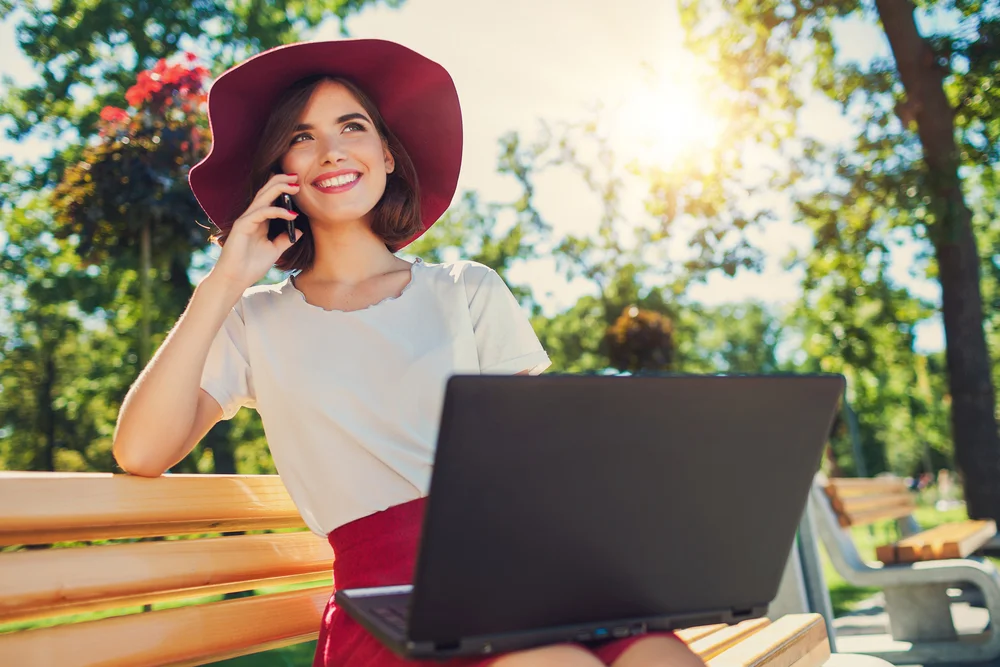 blogger-girl-on-mobile-phone-and-working-laptop.jpg