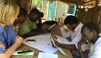 Mary McFarland participates in a brainstorming session with JC:HEM students in the Kakuma refugee camp in Kenya.
