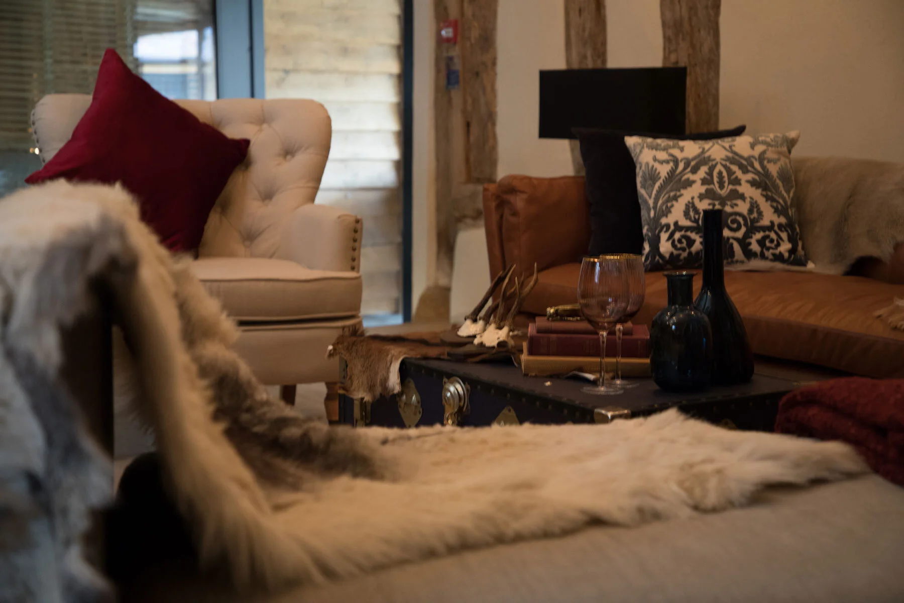 Medium brown leather sofa, cream armchair with fur throw