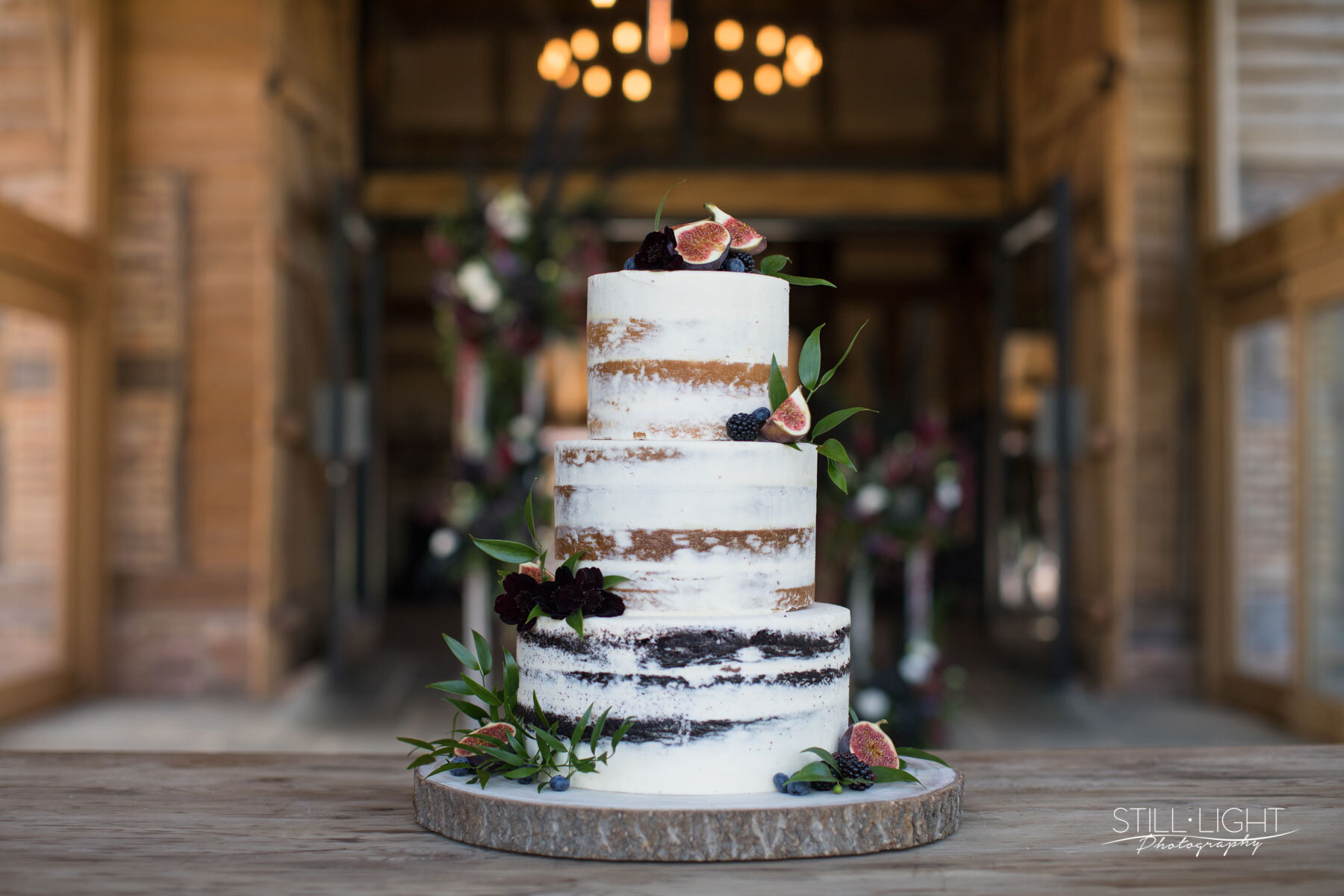 Contemporary wedding cake decorated with fresh white flowers and delicate foliage"