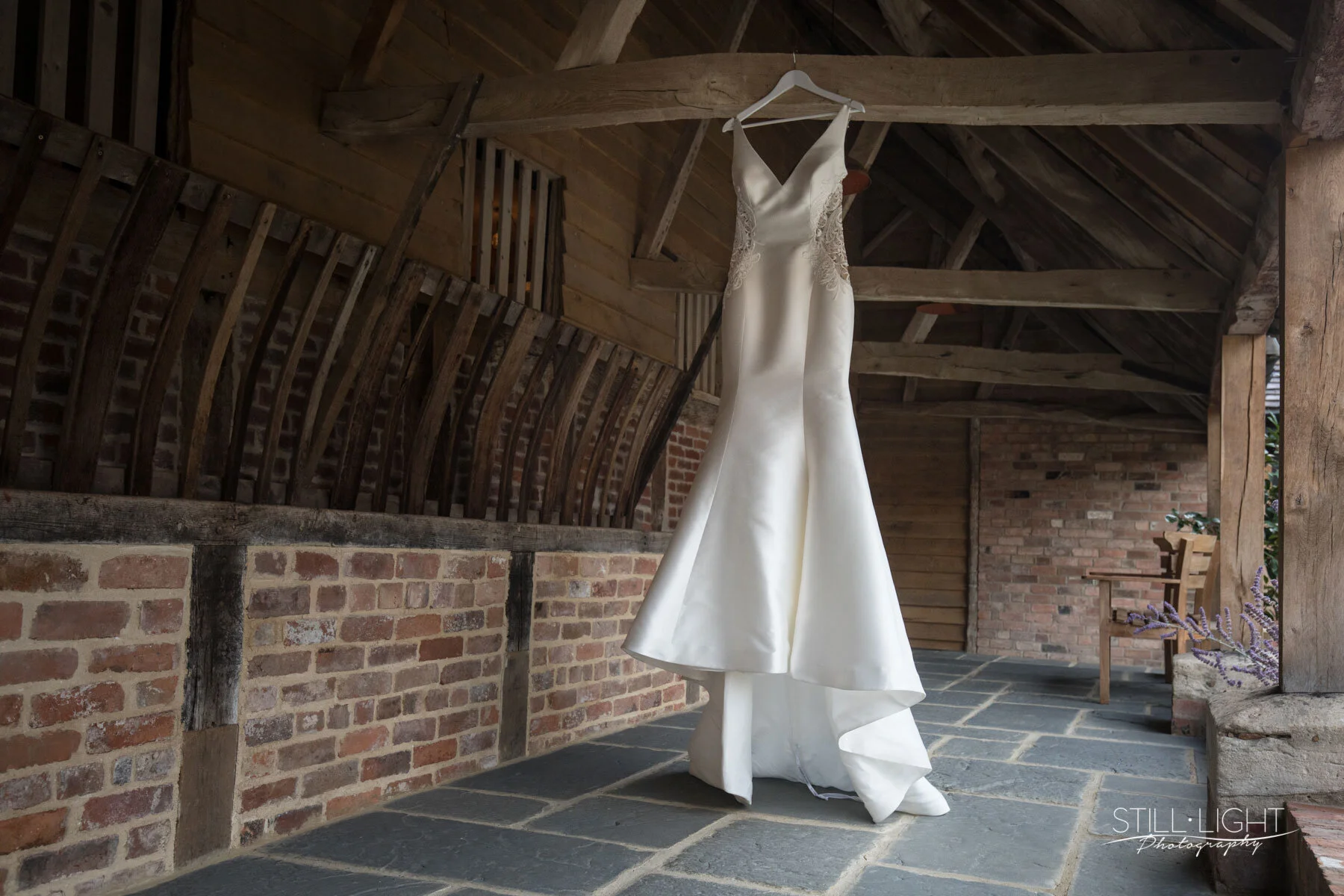 Modern and simplistic wedding dress hung from the eves in the stalls