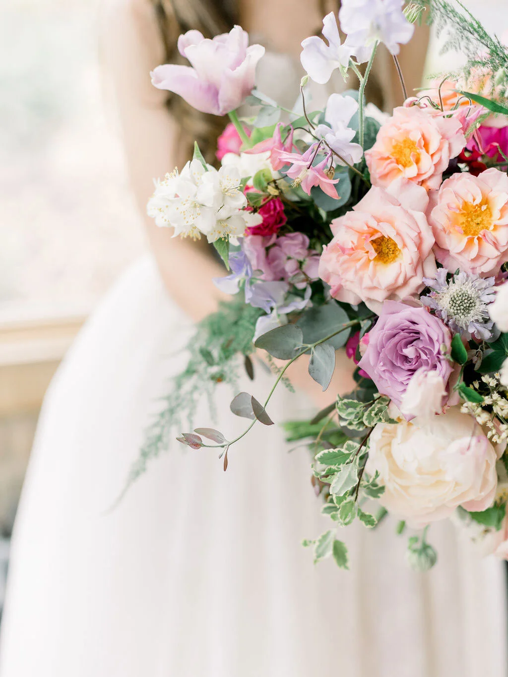 Garden-inspired bridal bouquet featuring sweet peas, roses and seasonal foliage