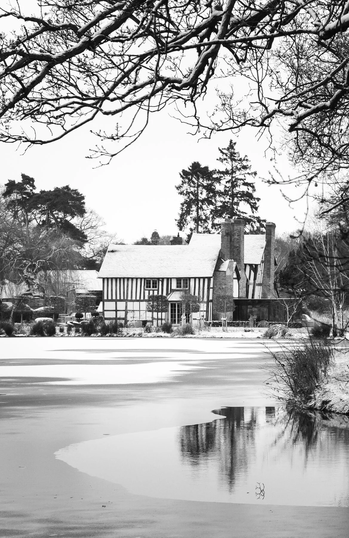 Shot of the iced over lake and black and white Hanley Hall building in the backdrop