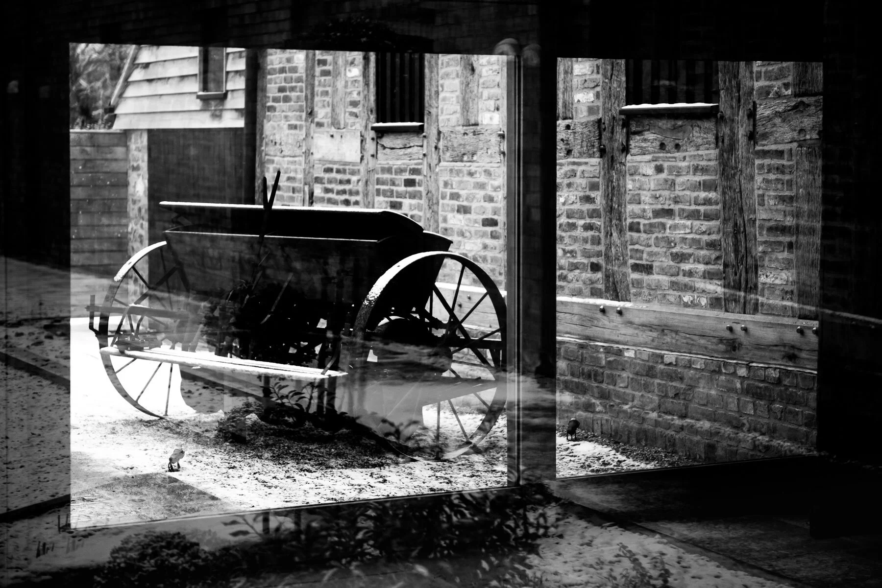 Looking through the window to the other side of the barns where an old cart / trailer