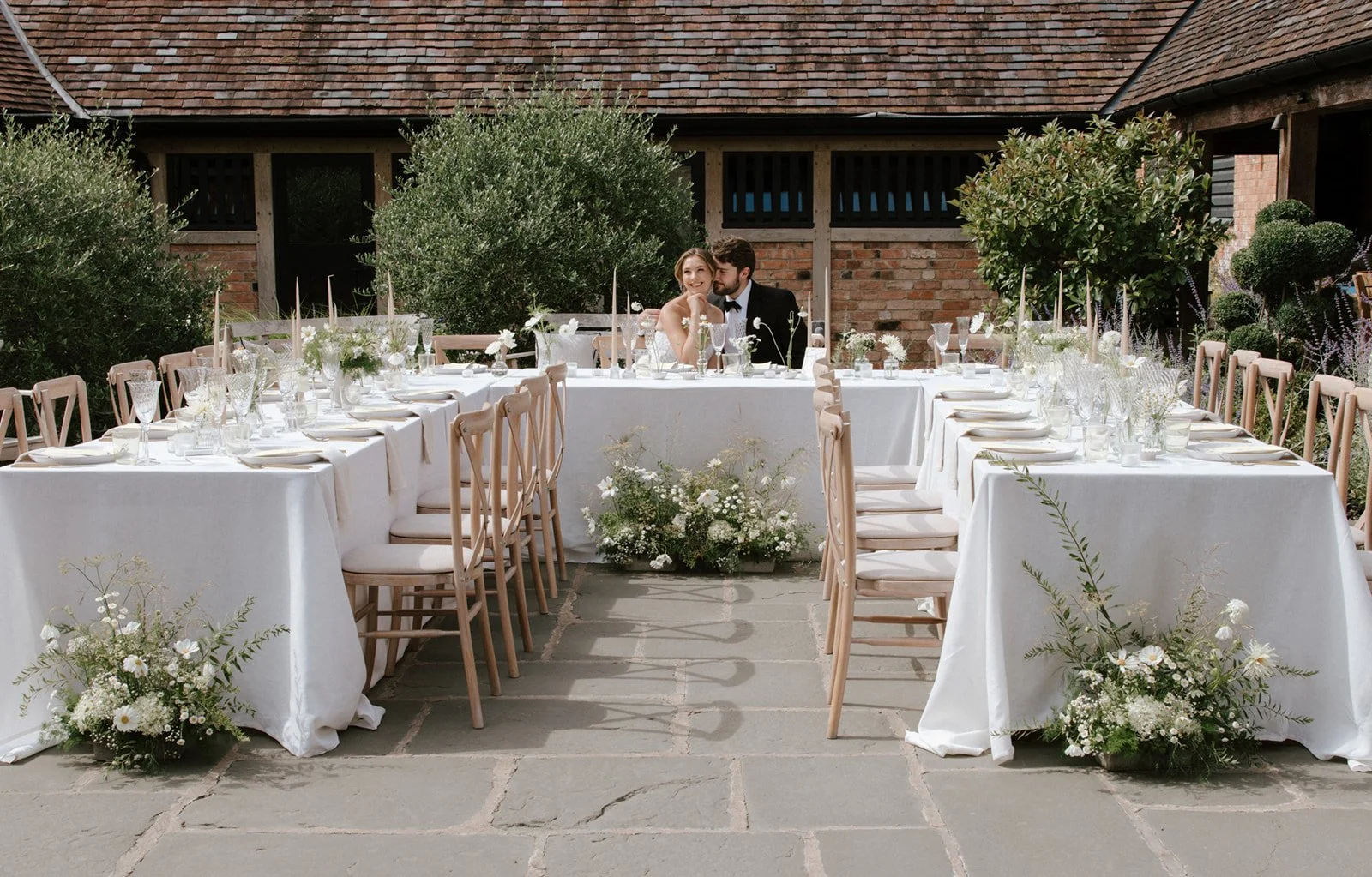 Wedding breakfast table decorated with taper candles and wild floral arrangements