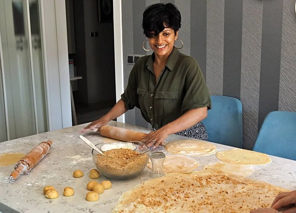 A woman with short hair rolls out pastry at a baklava making class in Turkey