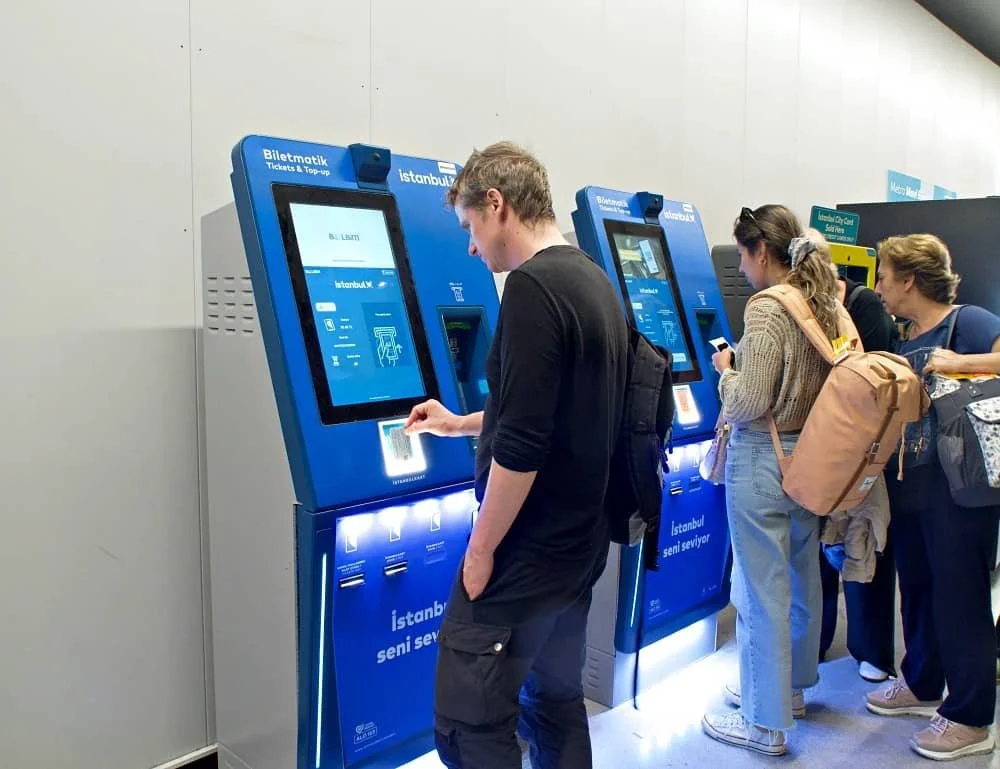 A man checks the balance on his Istanbulkart at an electronic top-up machine at an airport