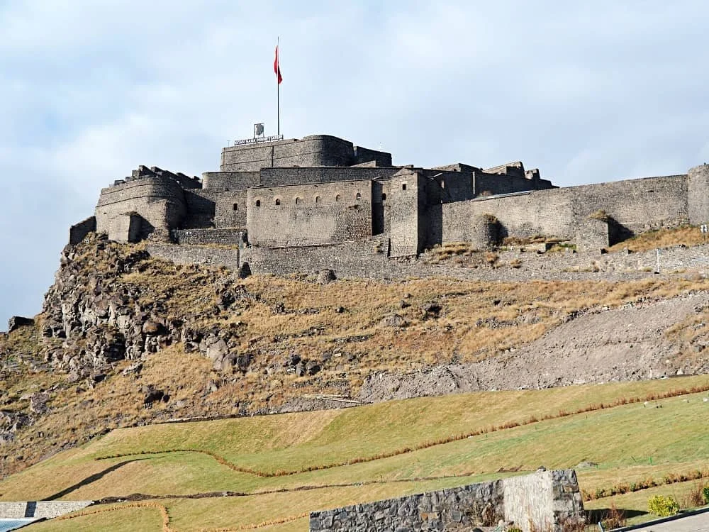 Kars Castle on a hill with a Turkish flag above it on a hill in Kars city centre