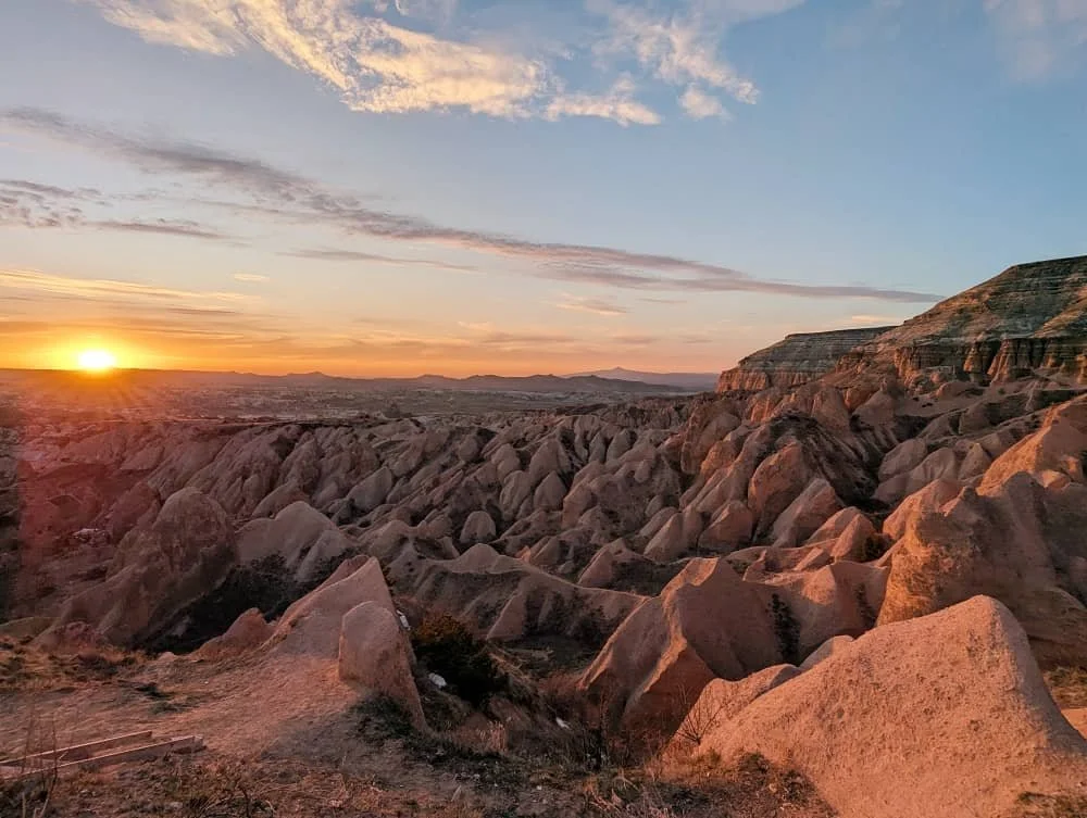 sunset across the rock formations in red and rose valley in cappadocia