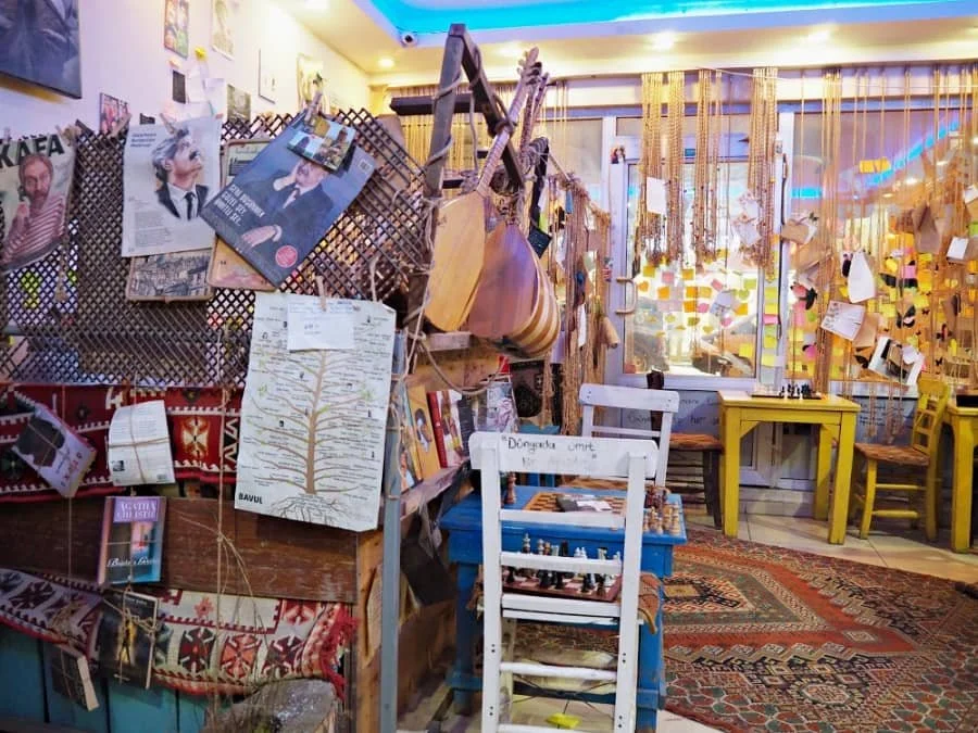 An eclectically decorated cafe in Kars with Turkish rugs, musical instruments and brightly coloured wooden furniture.