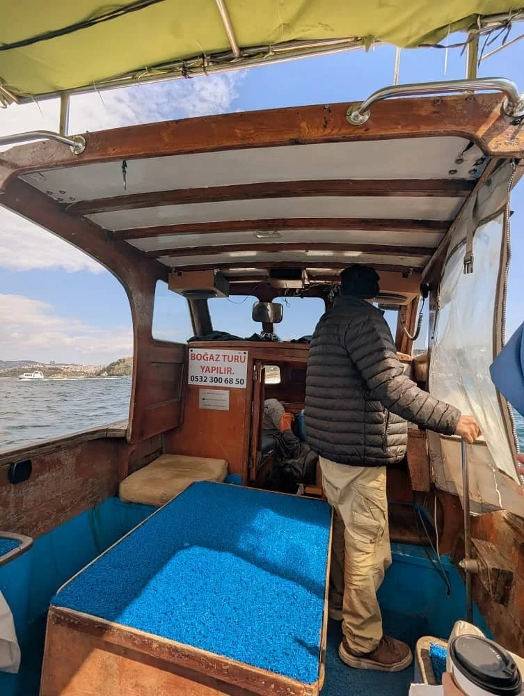 Inside the boat showing the captain driving and a small seating area