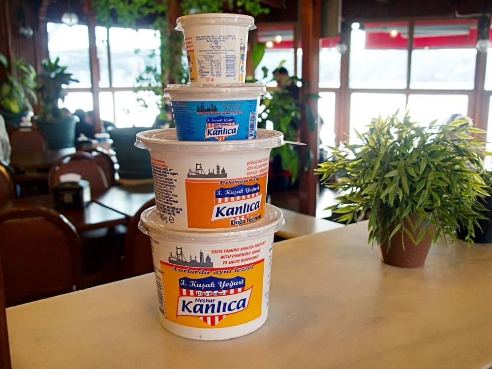 Kanlica yogurt tubs of various sizes stacked on top of each other in a cafe in Kanlica in Istanbul
