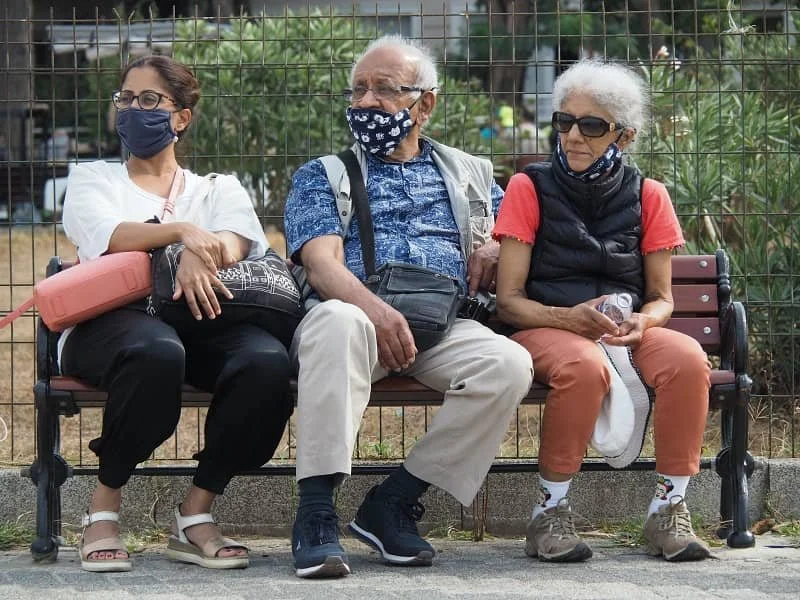 Three people (Sasha's sister, dad and mum) sitting on a bench wearing Covid masks in the Princes' Islands in Istanbul