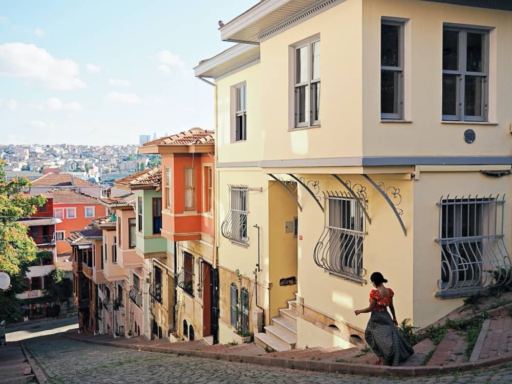 14 day travel itinerary turkey A girl walking down a steep cobbled street past brightly coloured houses, best tourist places in turkey