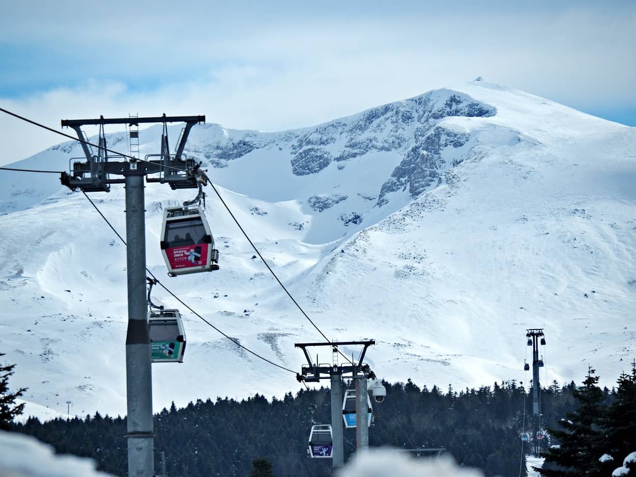 Cable cars travelling up Uludag mountain in Bursa, with snowy mountains in the background,