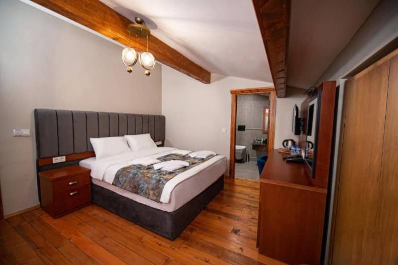 A large double bedroom with wooden floors at Ahiska Palace Otel in Kars, hotels in kars turkey