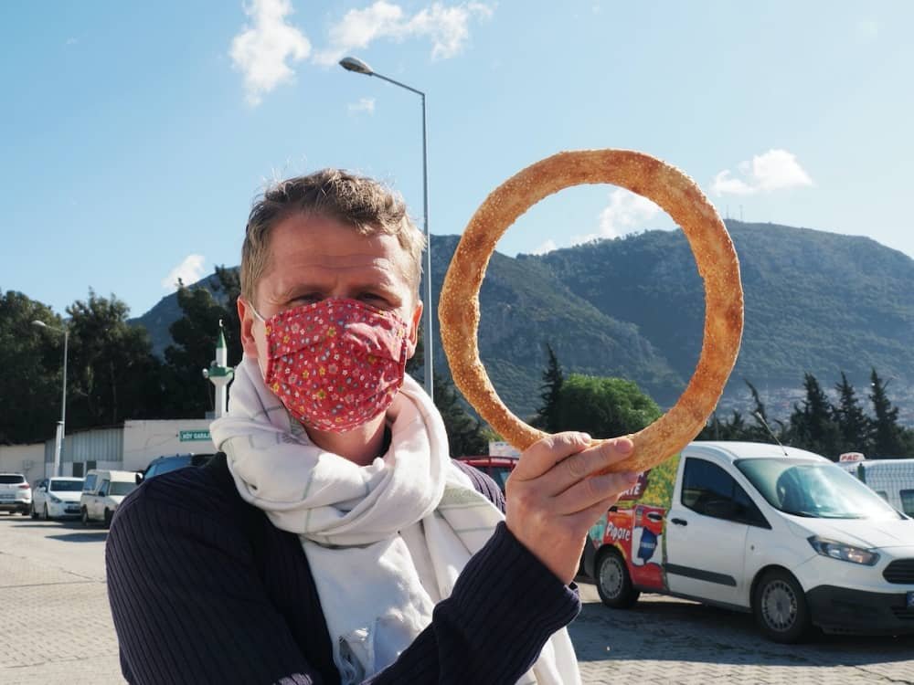 14 day travel itinerary turkey A man wearing a flowered face mask holds up a circular bread (like a bagel) known as simit in Antakya in Turkey