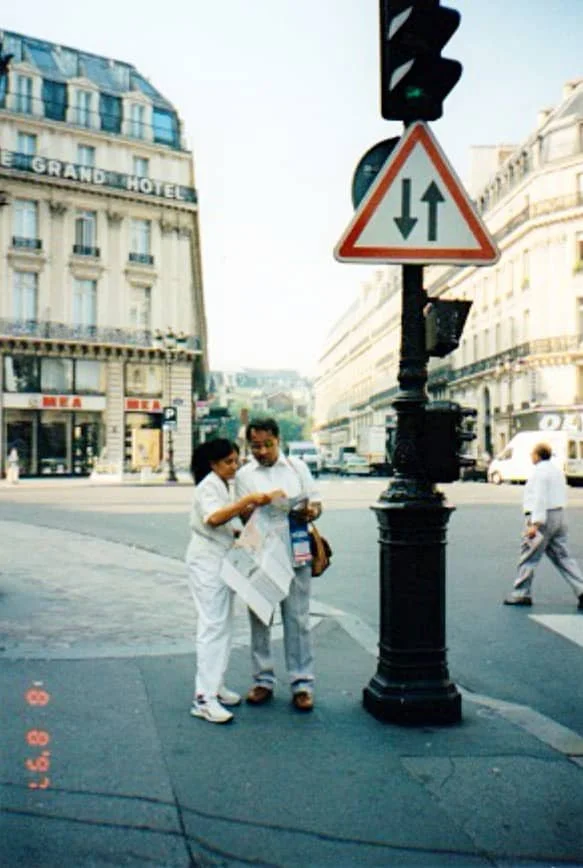 Sasha's parents look at a map on the streets of Paris in 1997