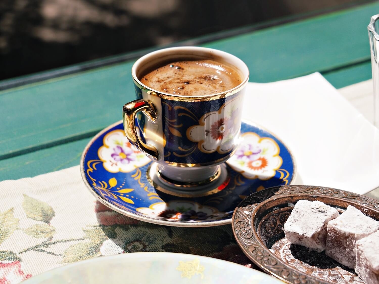 A Turkish coffee on a blue flowered ceramic cup with Turkish delight