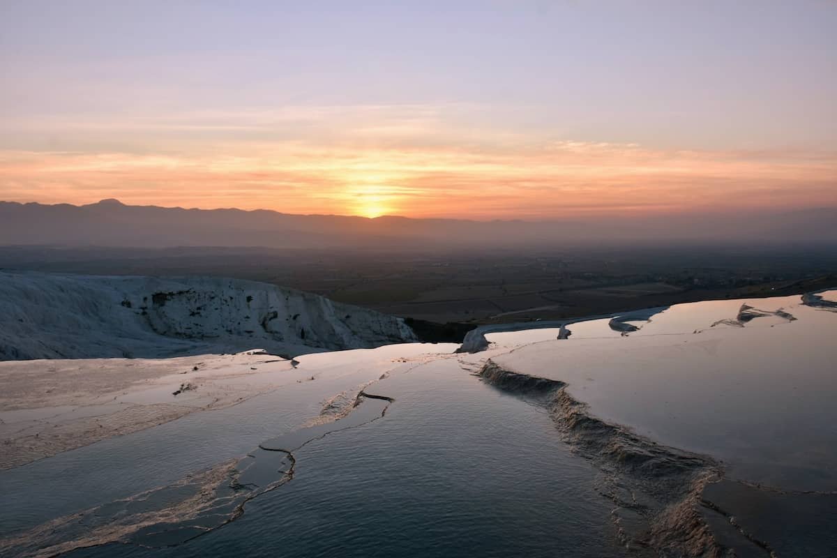 14 day travel itinerary turkey A stunning sunset reflected in the water of the thermal pools at Pamukkale hot springs in TĂŒrkiye.