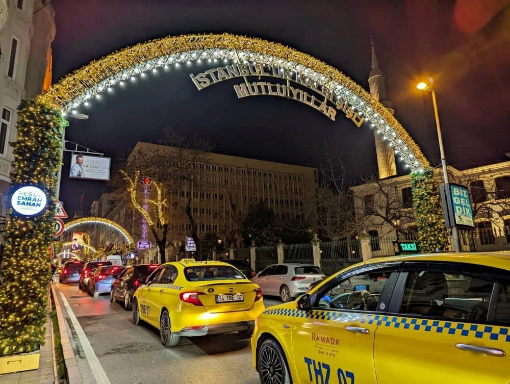 Yellow Istanbul taxis pass under New Year decorations in NIsantasi district in Istanbul