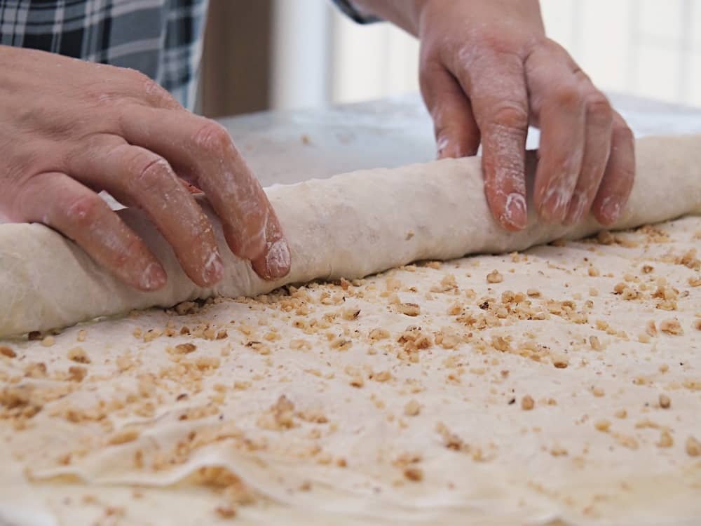 close up of hands rolling homemade baklava in a turkish cooking class