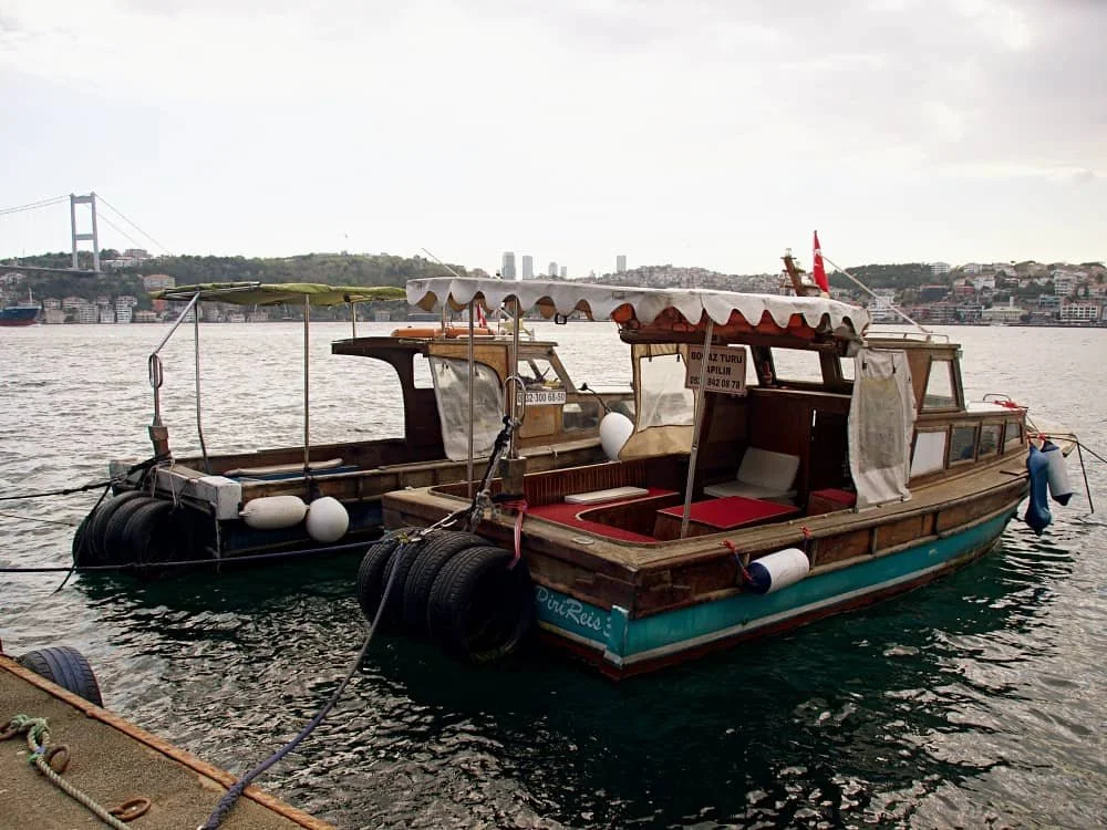 Two small,  traditional wooden motor boats tied to the pier near Kanlica ferry terminal in Istanbul