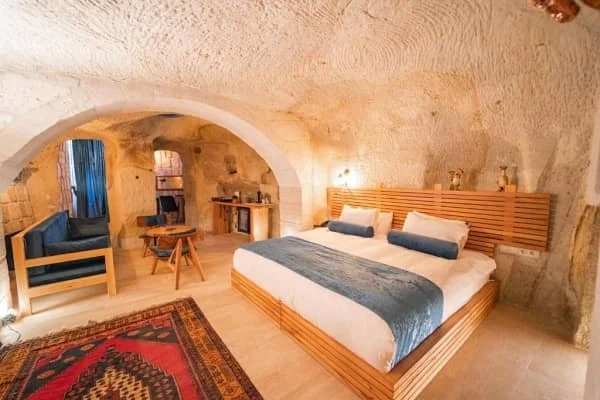 A bright and cosy room decorated with pine furniture and Turkish rugs at Agarta Cave Hotel, best hotel view cappadocia