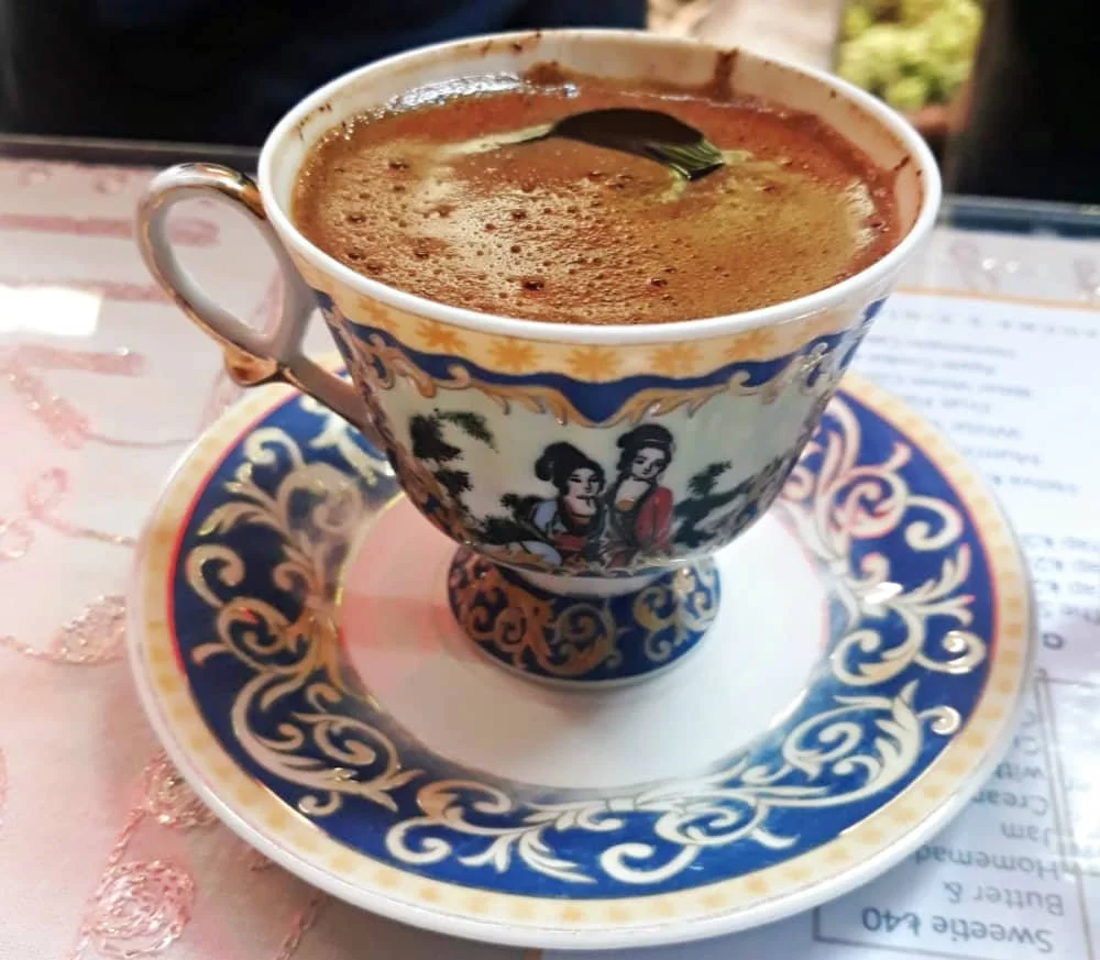 Close up of a Turkish coffee in a vintage cup decorated with two ladies at Velvet Cafe in Balat Istanbul