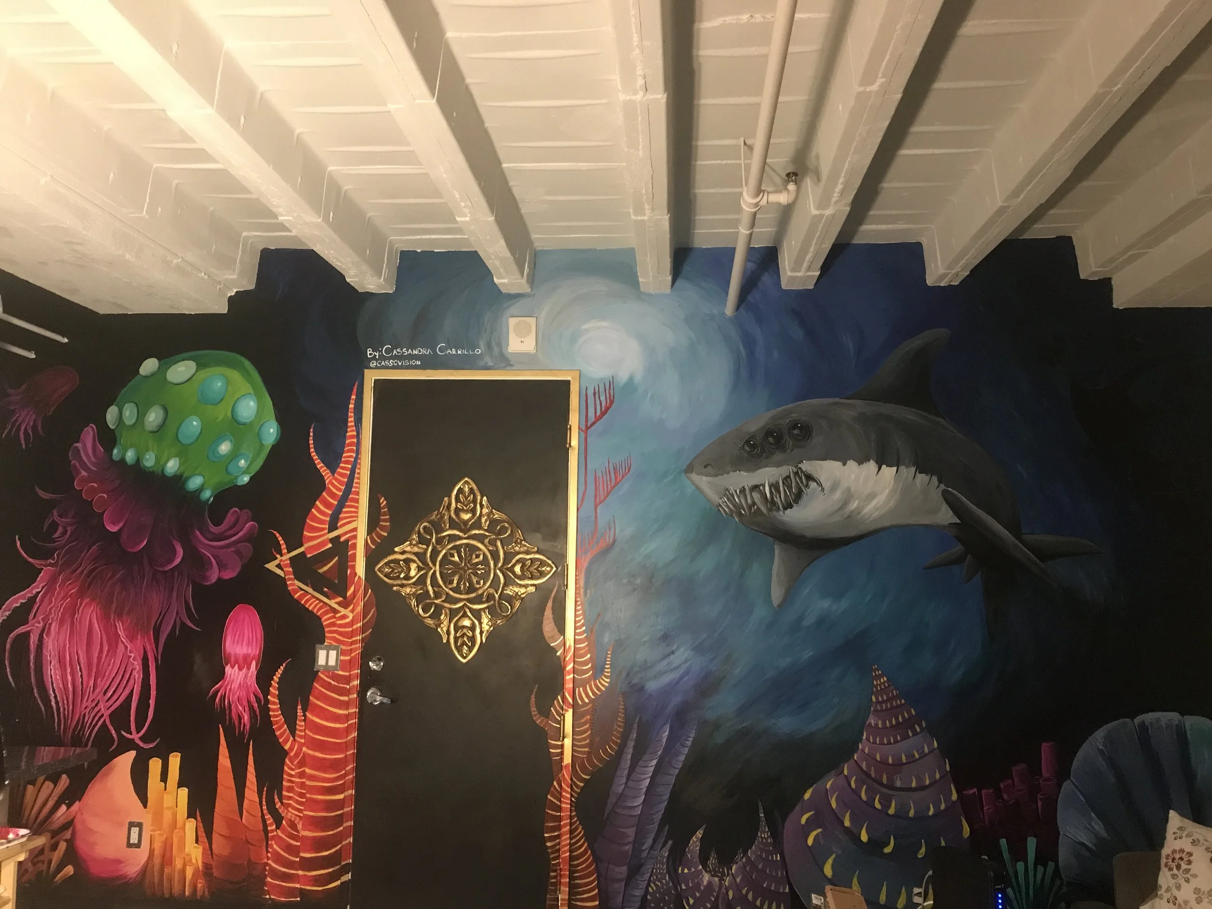 Colorful underwater scene mural with a large great white shark, jellyfish, and coral.