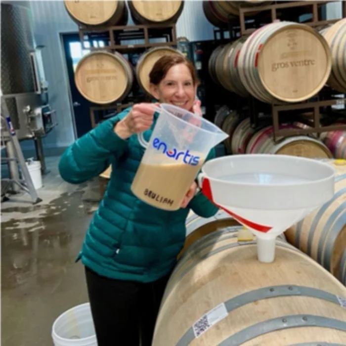 adding a yeast juice mixture to wine barrels